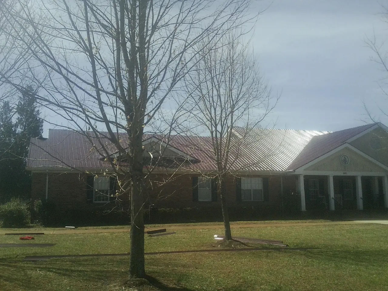 Red metal roof on a brick building seen from the front lawn in Orlando